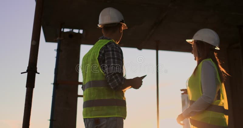 Female architect and construction worker shaking hands. Low angle view, copy space.