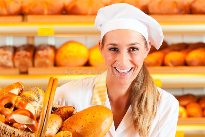 Žena pekař nebo prodavačka v její pekárně prodává čerstvý chléb, pečivo a pekárenské výrobky v košíku.