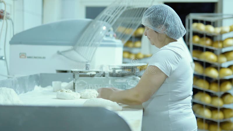 The Female Baker Roll Bread on Table Bakery Factory Wheat Flour Knead The Female Baker Roll Bread on Table Bakery Factory Wheat Flour Knead