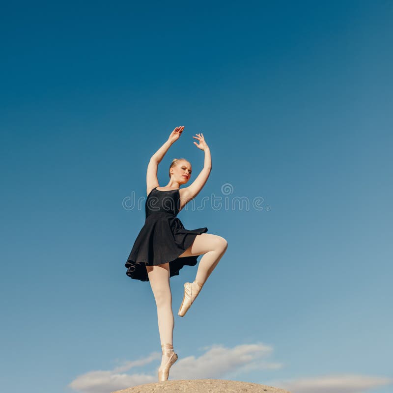 Female ballet dancer practicing dance moves on a rock top