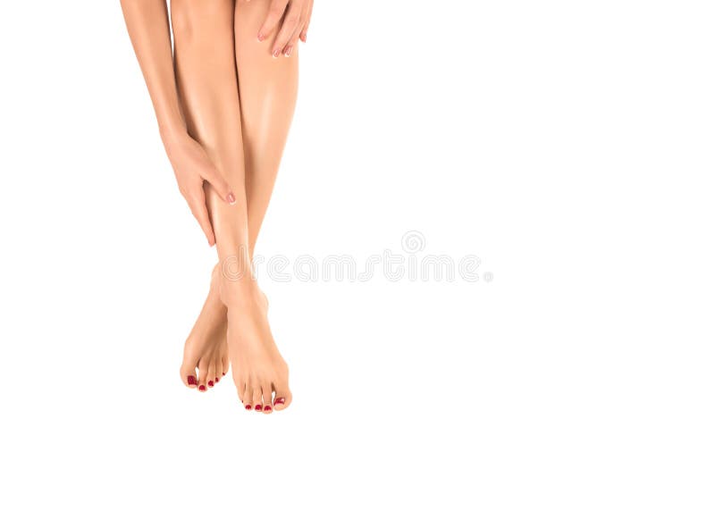 Female barefoot legs. Woman touch her smooth skin by her hand, classic red pedicure, isolated on white.