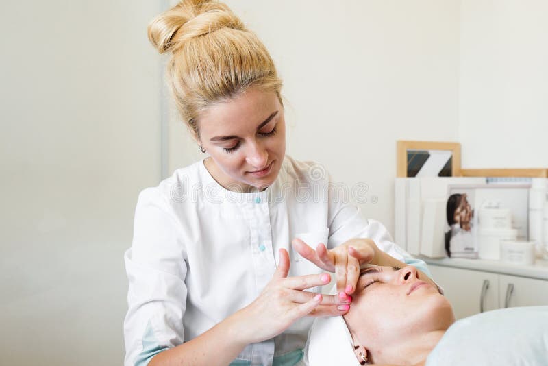 Female Beautician Doing Facial Massage Her Female Client In A Beauty Clinic Stock Image Image