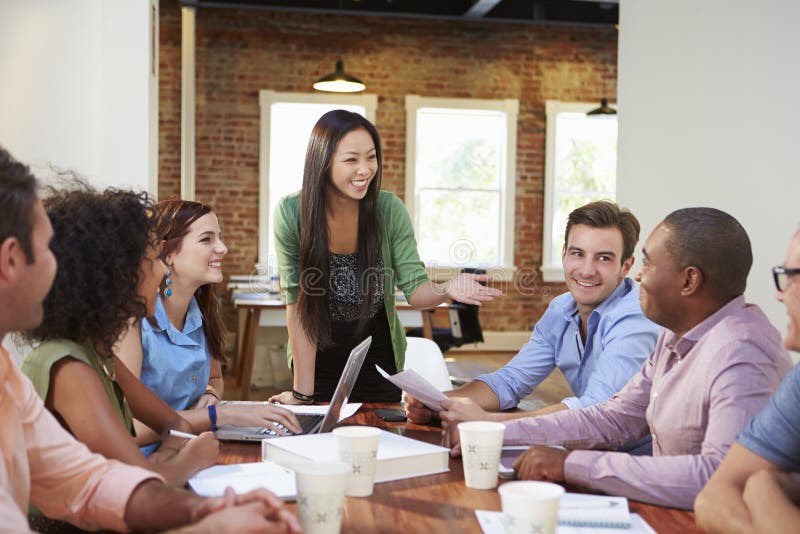 Female Boss Addressing Office Workers At Meeting stock photo Female Boss Addressing Office Workers At Meeting stock photo