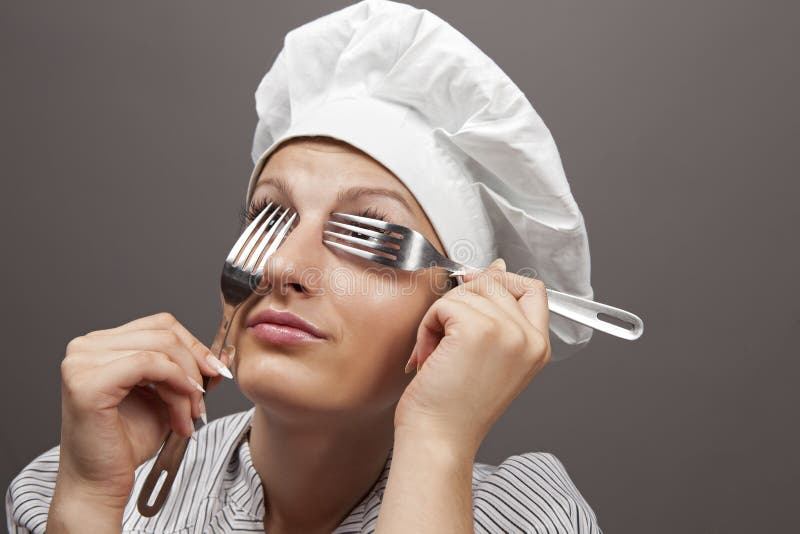 Female Chef looking through forks