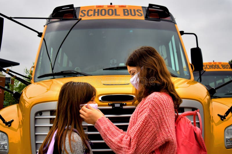 Coronavirus school: Child face mask. Children helping with face masks with school bus. royalty free stock photo Coronavirus school: Child face mask. Children helping with face masks with school bus. royalty free stock photo