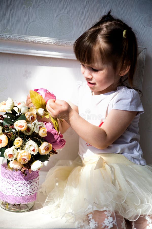 Photo of Female child sitting on the chest of drawers