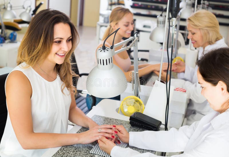 Female Clients Doing Nails in Nail Salon in Afternoon Stock Image