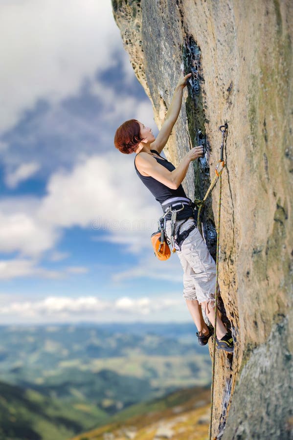 Female climber climbing with rope on a rocky wall stock photography Female climber climbing with rope on a rocky wall stock photography