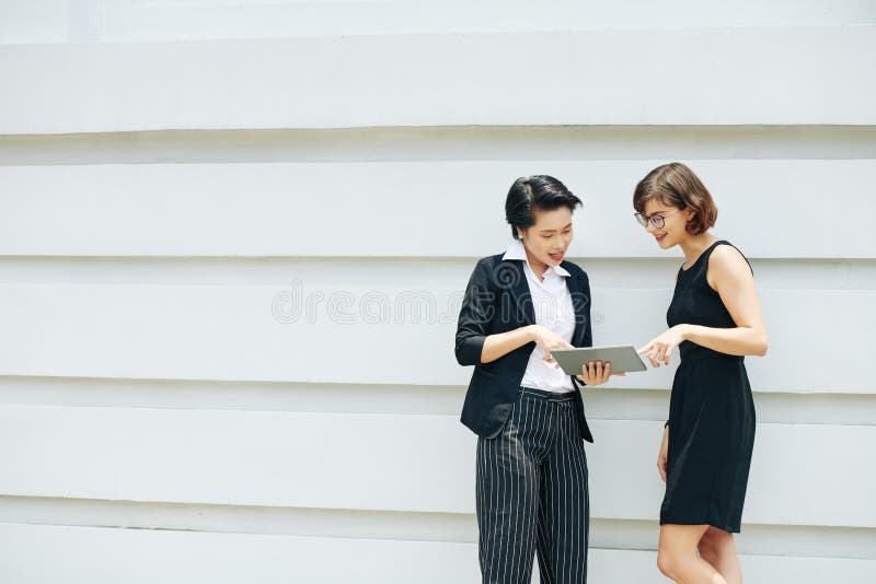 Female colleagues discussing report stock photo