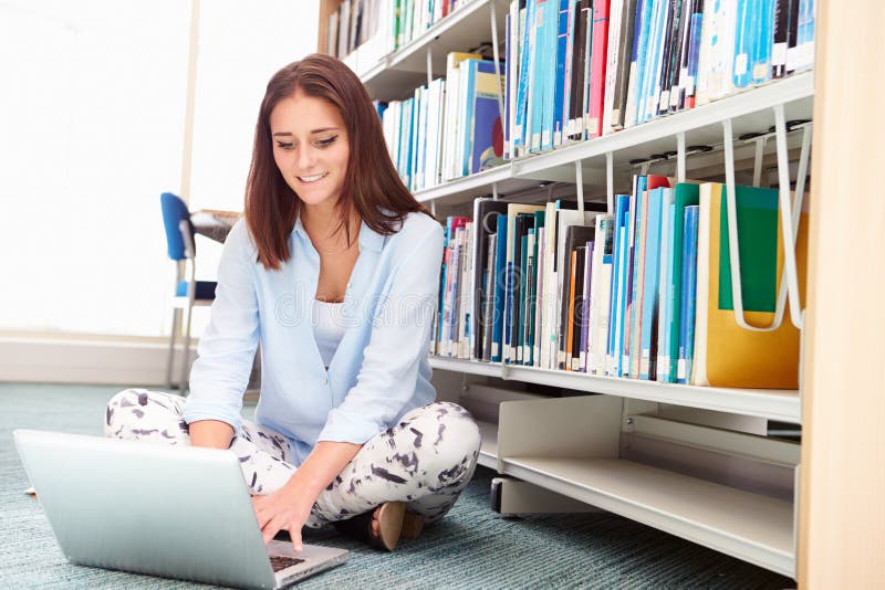 Female College Student Studying In Library With Laptop stock image Female College Student Studying In Library With Laptop stock image