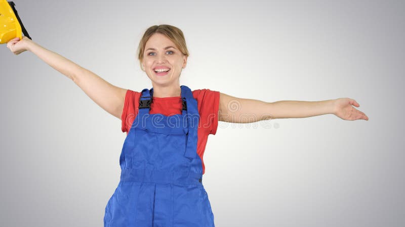 Female construction worker dancing with hardhat on gradient background. stock photography Female construction worker dancing with hardhat on gradient background. stock photography