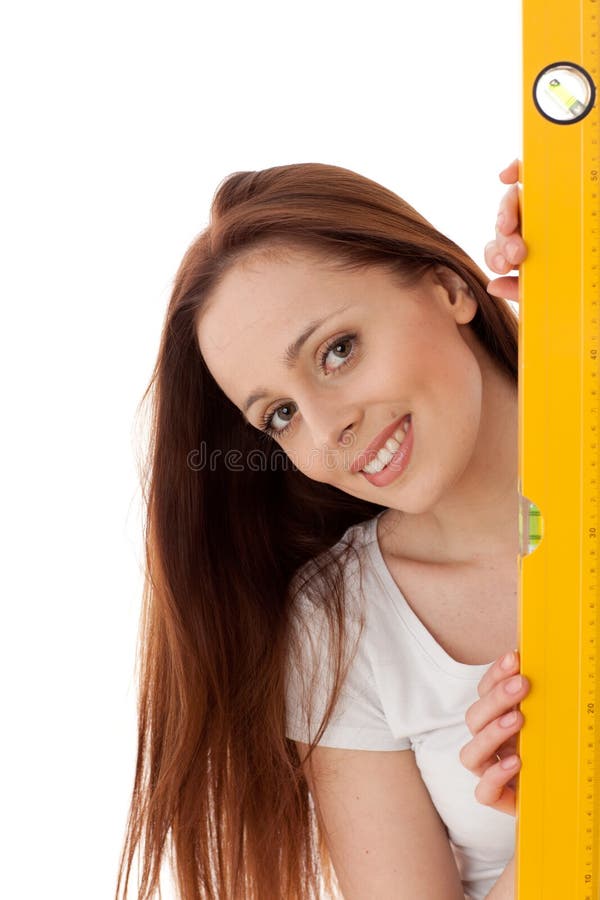 Young female construction worker with yellow level on a white background. Young female construction worker with yellow level on a white background.