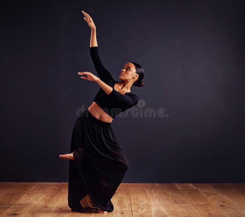 Mysteries of the dance. Female contemporary dancer in a dramatic pose against dark background.