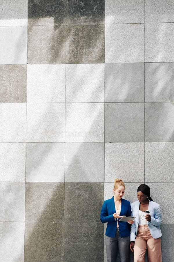 Female coworkers discussing report stock image