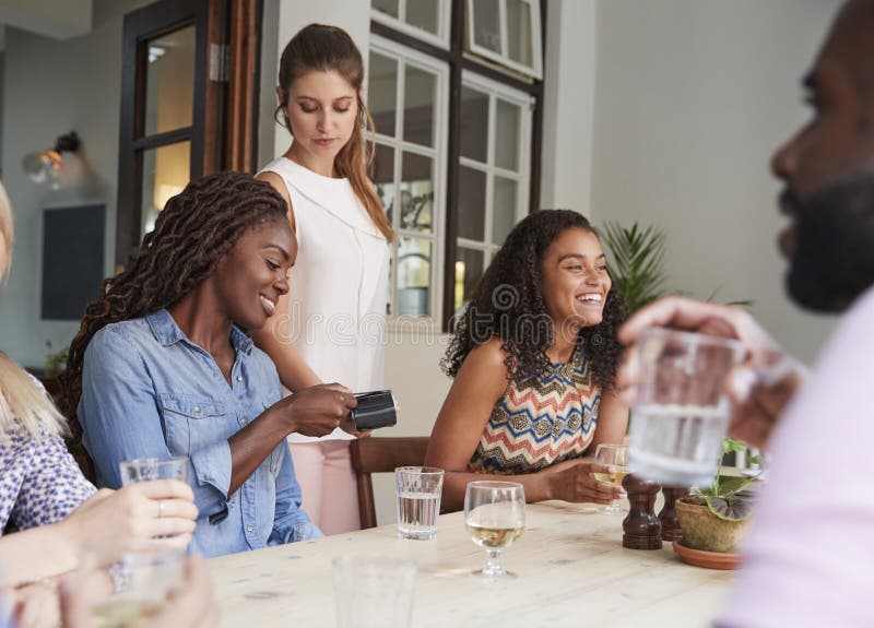 Female Customer In Restaurant Paying Bill Using Contactless Credit Card Terminal stock photography Female Customer In Restaurant Paying Bill Using Contactless Credit Card Terminal stock photography