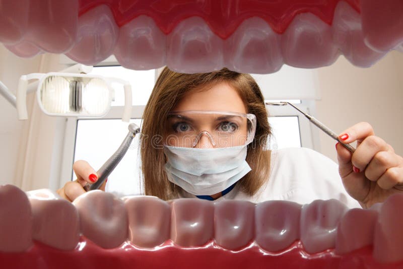 Vista al femminile giovane dentista dentale strumenti da pazienti in bocca.