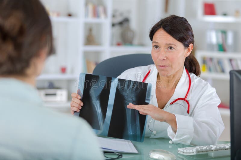 Female dentist showing x-rays to patient royalty free stock photography Female dentist showing x-rays to patient royalty free stock photography