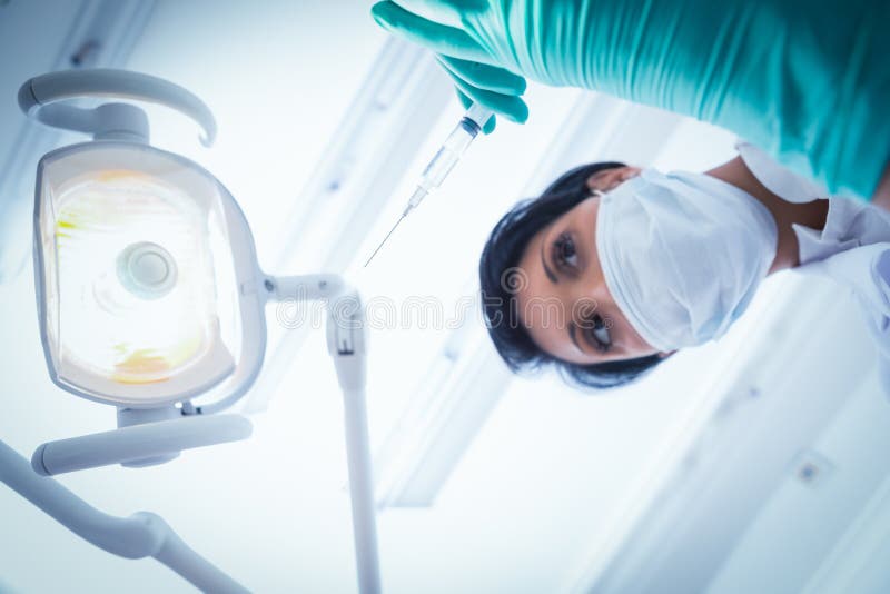 Female dentist in surgical mask holding injection royalty free stock photos Female dentist in surgical mask holding injection royalty free stock photos
