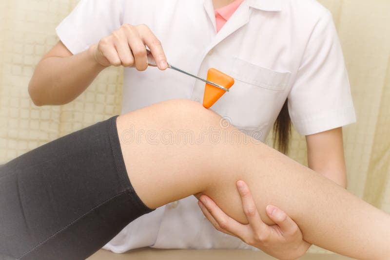 Female doctor doing reflex test stock photo Female doctor doing reflex test stock photo