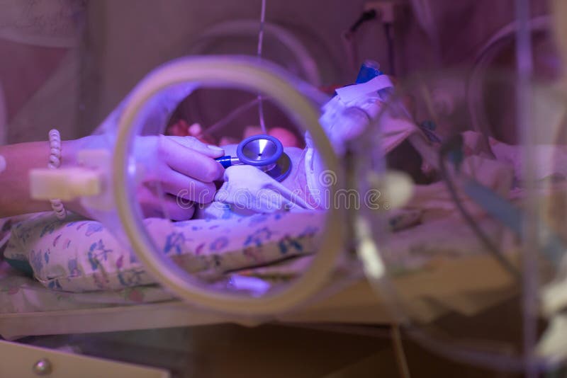 Female doctor examining newborn baby in incubator. Close up female hands with a stethoscope royalty free stock photos Female doctor examining newborn baby in incubator. Close up female hands with a stethoscope royalty free stock photos
