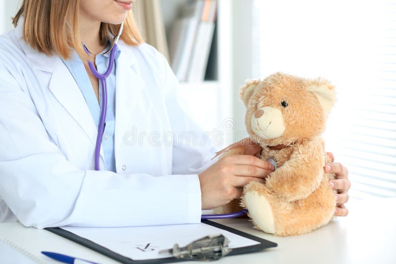 Female doctor examining a nTeddy bear patient by stethoscope. stock image Female doctor examining a nTeddy bear patient by stethoscope. stock image