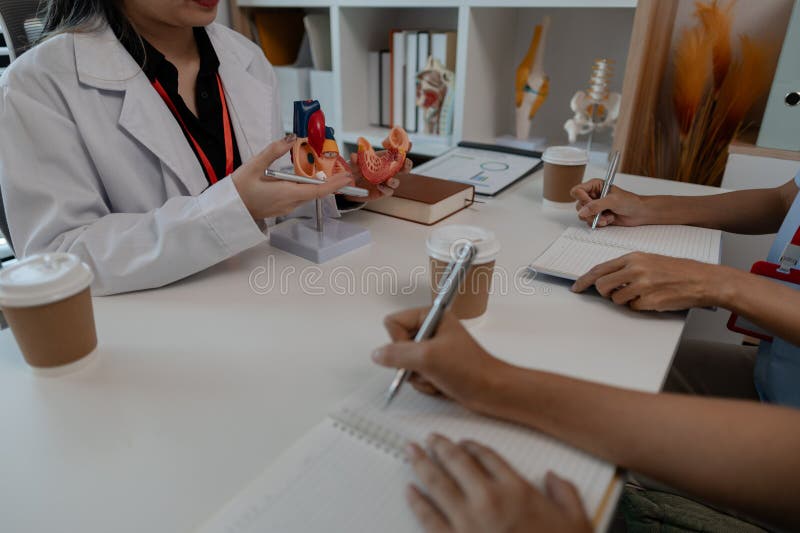 A female doctor is explaining the systems in the human body to two interns, three doctors are meeting to discuss the most stock photos