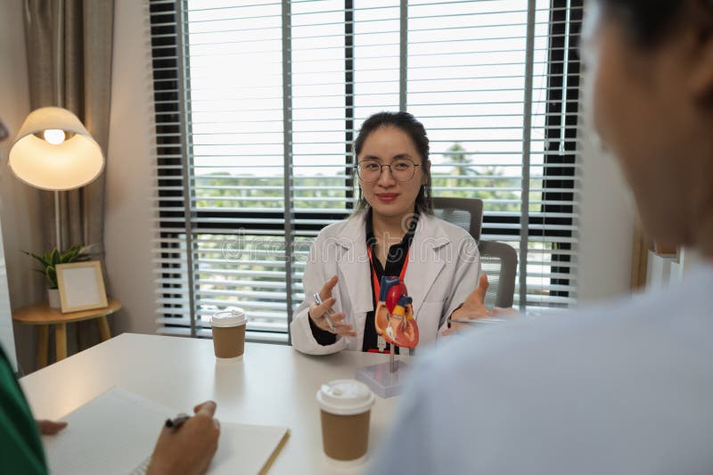 A female doctor is explaining the systems in the human body to two interns, three doctors are meeting to discuss the most royalty free stock photos
