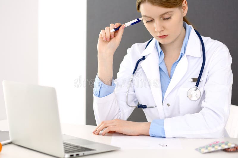 Female doctor filling up medical form on clipboard closeup. Physician finishing up examining his patient in hospital an