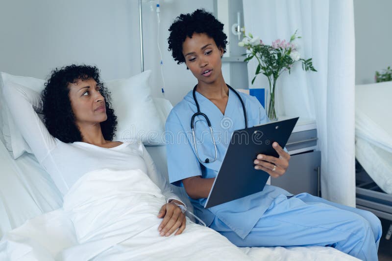 Female Doctor Interacting With Female Patient In The Ward Stock Image
