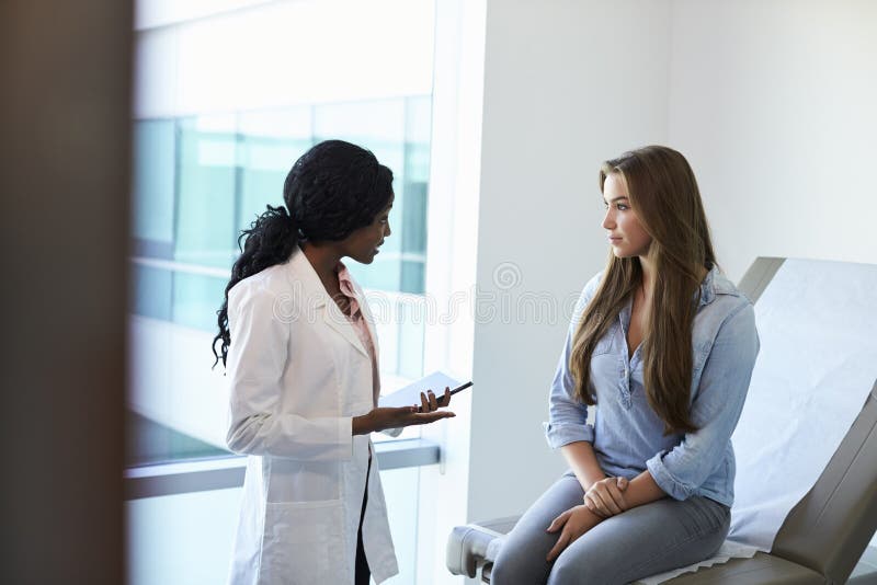 Female Doctor Meeting With Teenage Patient In Exam Room Stock Image