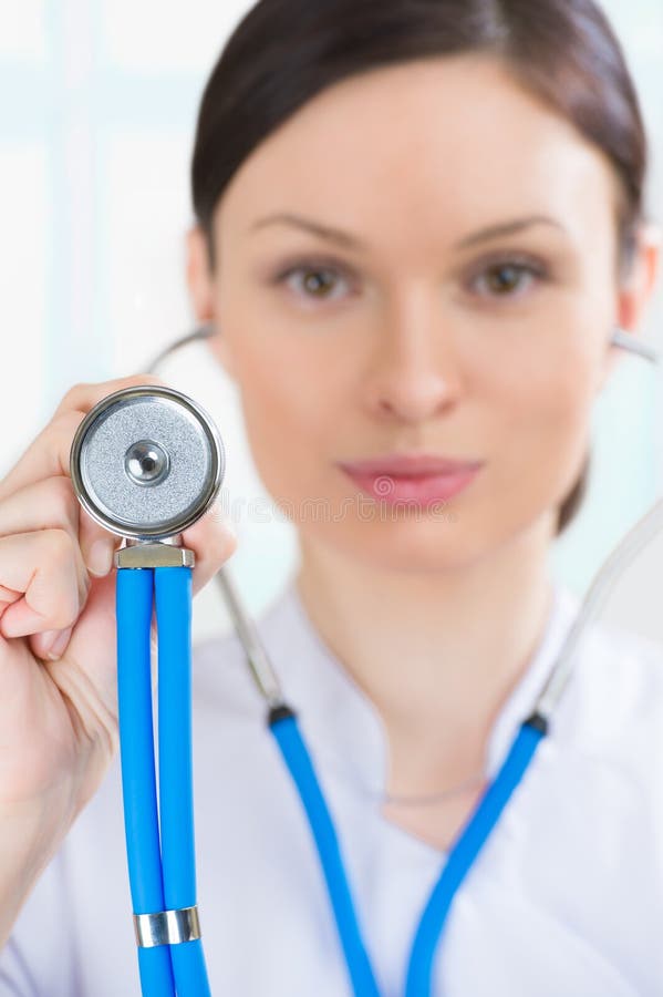 A Female Doctor With A Stethoscope Listening At Her Office Stock Image