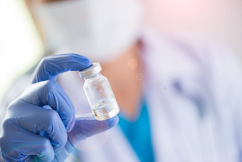 Female doctor with a stethoscope on shoulder holding syringe and