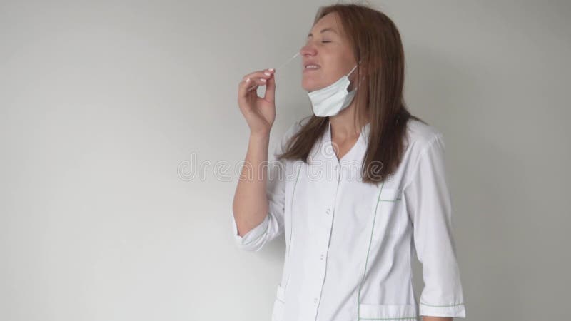 A female doctor takes a smear on a coronavirus from her nose