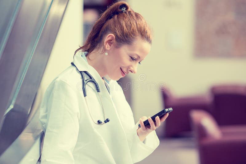 Female doctor in white lab coat using mobile smart phone