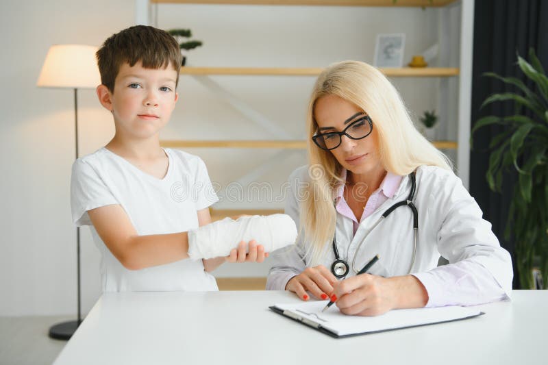 Female Doctor and Young Boy with a Broken Arm. Stock Image Image of