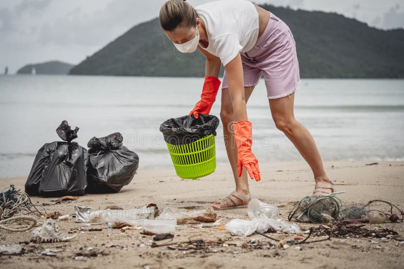 A Female Ecologist Volunteer Cleans the Beach on the Seashore from ...