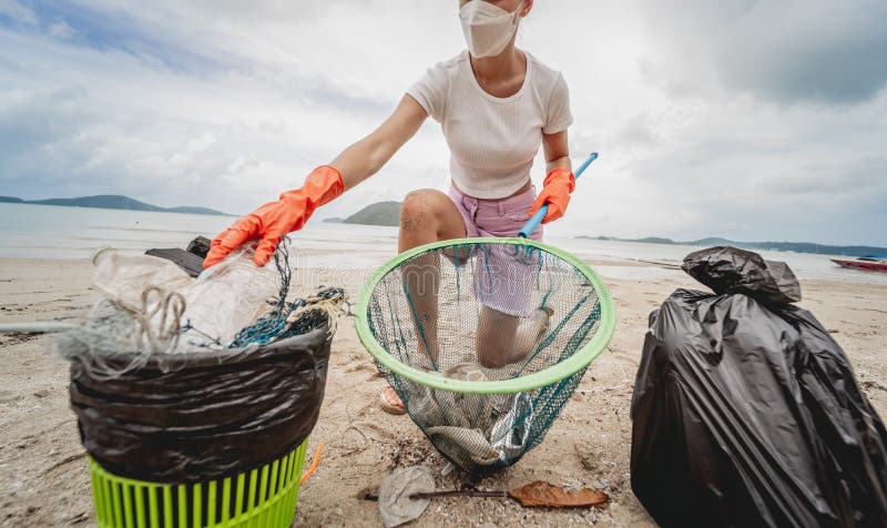 A Female Ecologist Volunteer Cleans the Beach on the Seashore from ...