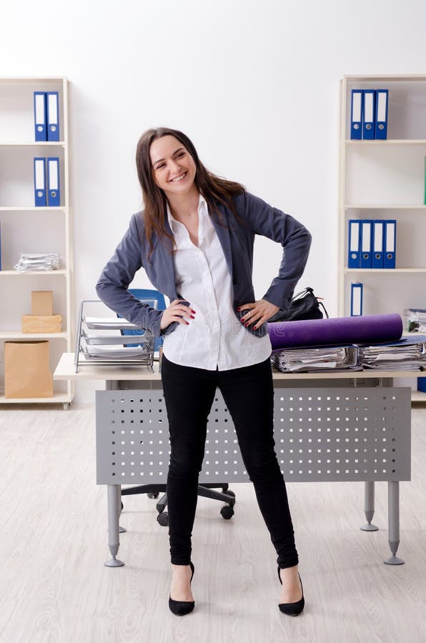 The female employee doing sport exercises in the office stock image