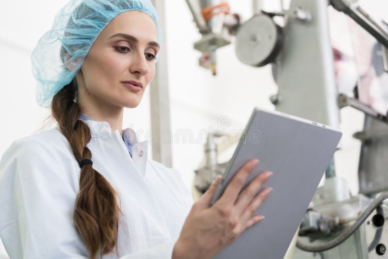 Woman expert analyzing information on tablet during work in contemporary factory stock photos Woman expert analyzing information on tablet during work in contemporary factory stock photos