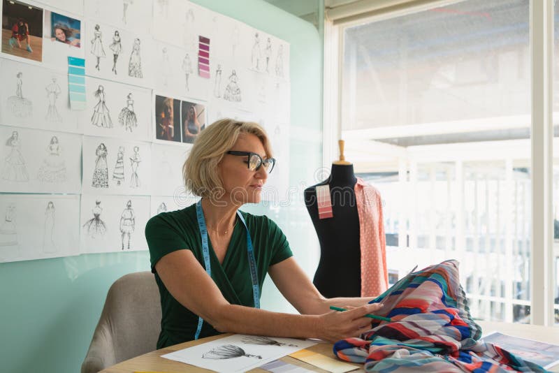 Female Fashion Designer Sitting with Hand on Hip in Design Studio