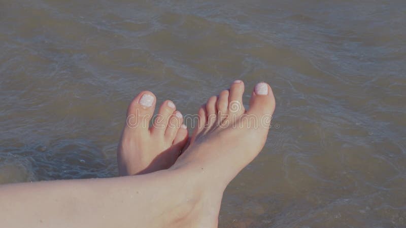 Picioare femele cu pedichiură elegantă, naturală, roz, frumoasă. stock footage