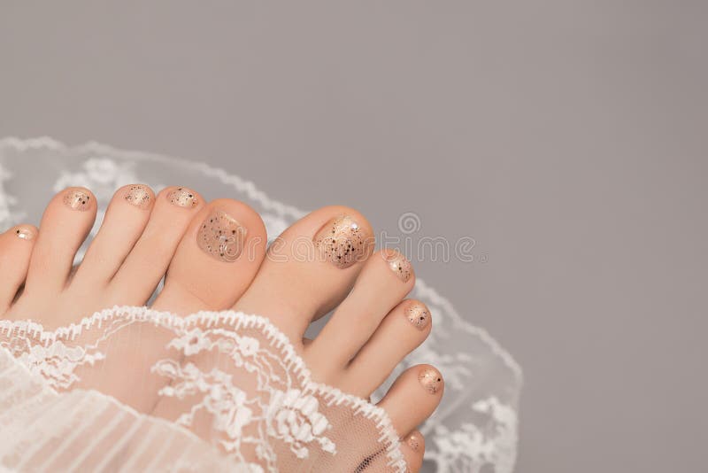Premium Photo  Beautiful female feet with pedicure nails, white gel  polish, glitter design