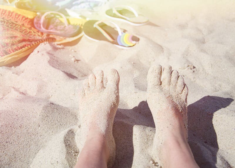 Female feet in the sand in the sun on the beach stock photos Female feet in the sand in the sun on the beach stock photos