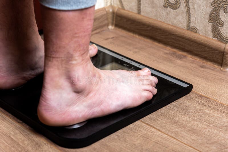 Female feet standing on black scales. royalty free stock images Female feet standing on black scales. royalty free stock images