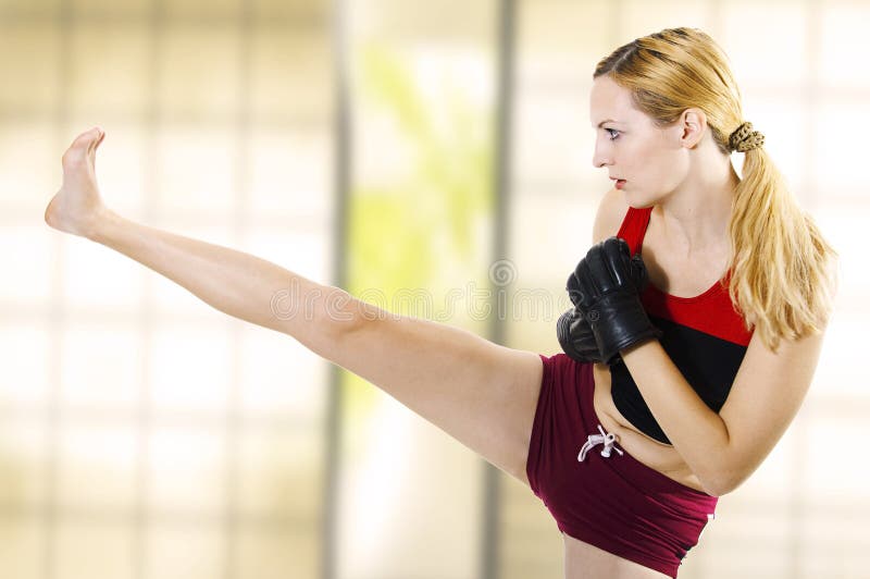 Female fighter kicking leg high side. Fitness