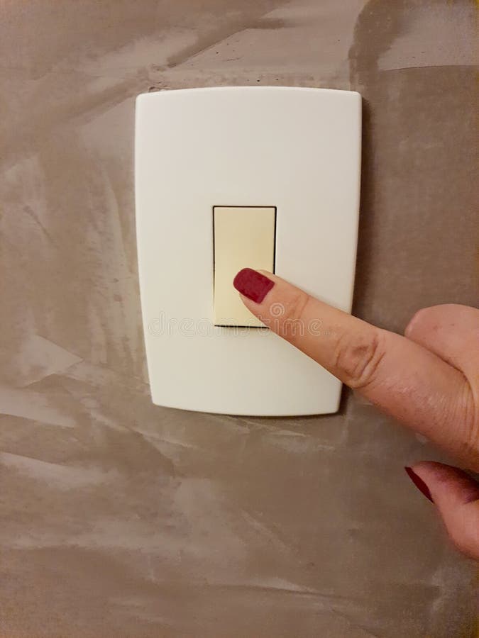 Female finger turning off the light switch, isolated on a modern painting. stock images