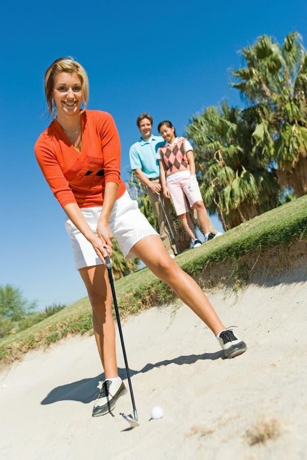 Female Golfer Hitting Ball From Sand Trap