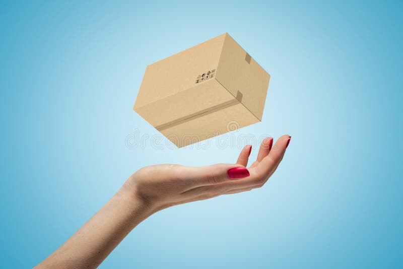 Female hand with cardboard box on blue background royalty free stock photo Female hand with cardboard box on blue background royalty free stock photo