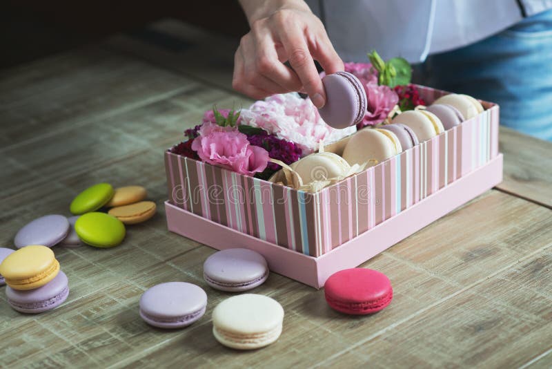 Female hand fills the decorated by delicious macaroon. royalty free stock photo Female hand fills the decorated by delicious macaroon. royalty free stock photo