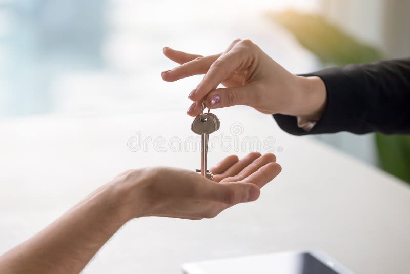 Female hand giving keys to male client, buying renting apartment